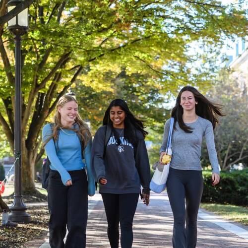 Three young women walk on campus